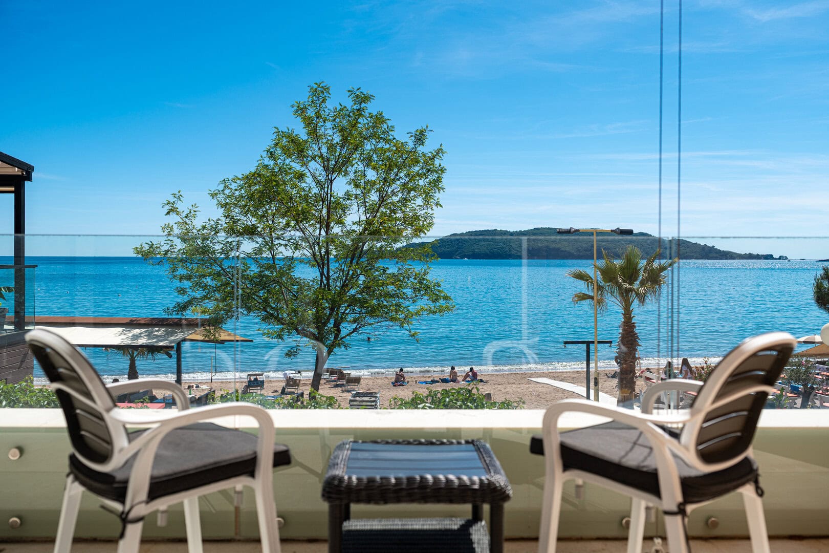 A sea view from the terrace of a luxury property in Montenegro, with tables and chairs to enjoy the beautiful landscape.
