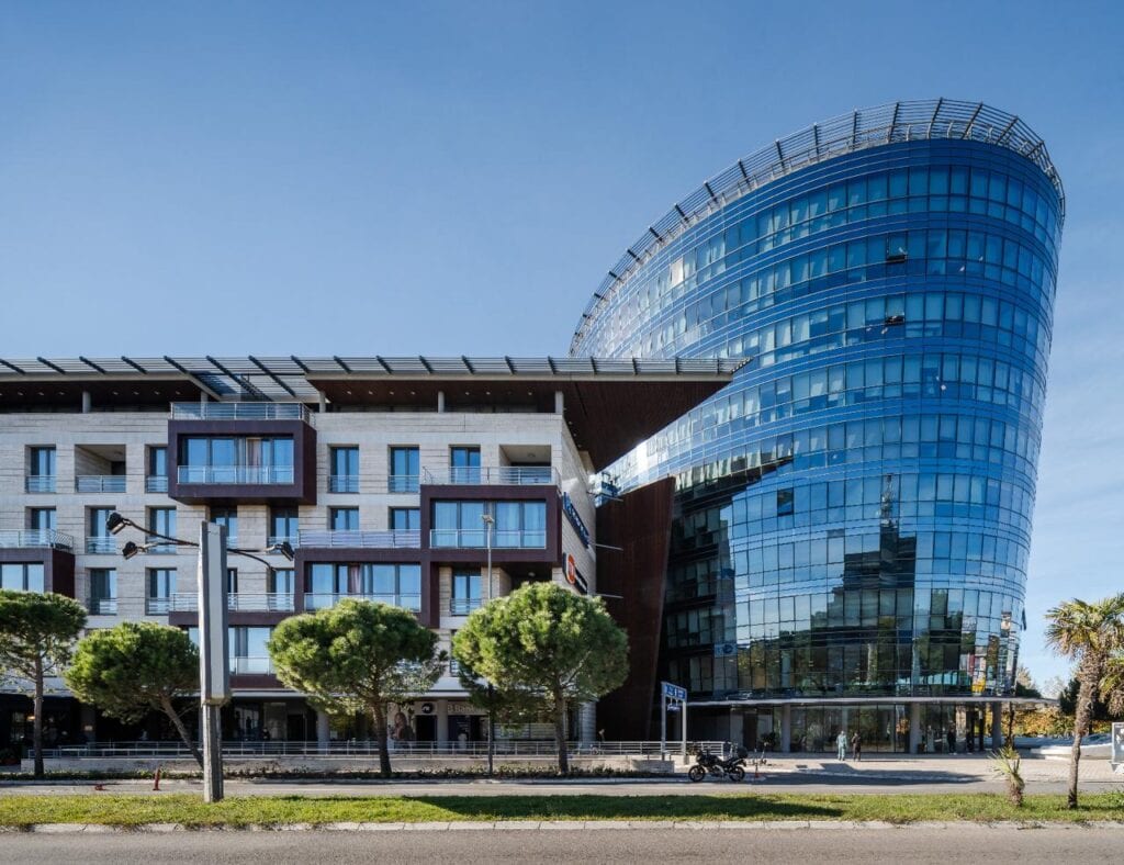 A modern business building with curved glass facades in Montenegro, ideal for luxury real estate and commercial spaces.