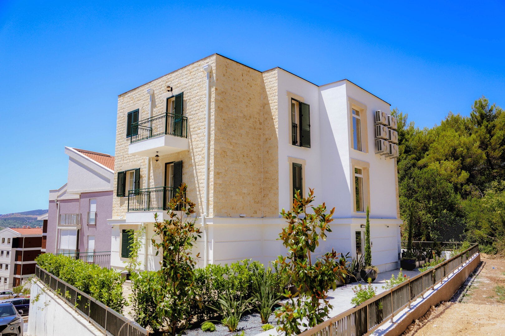 New two-bedroom apartments with garage spaces in Tivat, Montenegro, in a modern building with balconies and greenery.